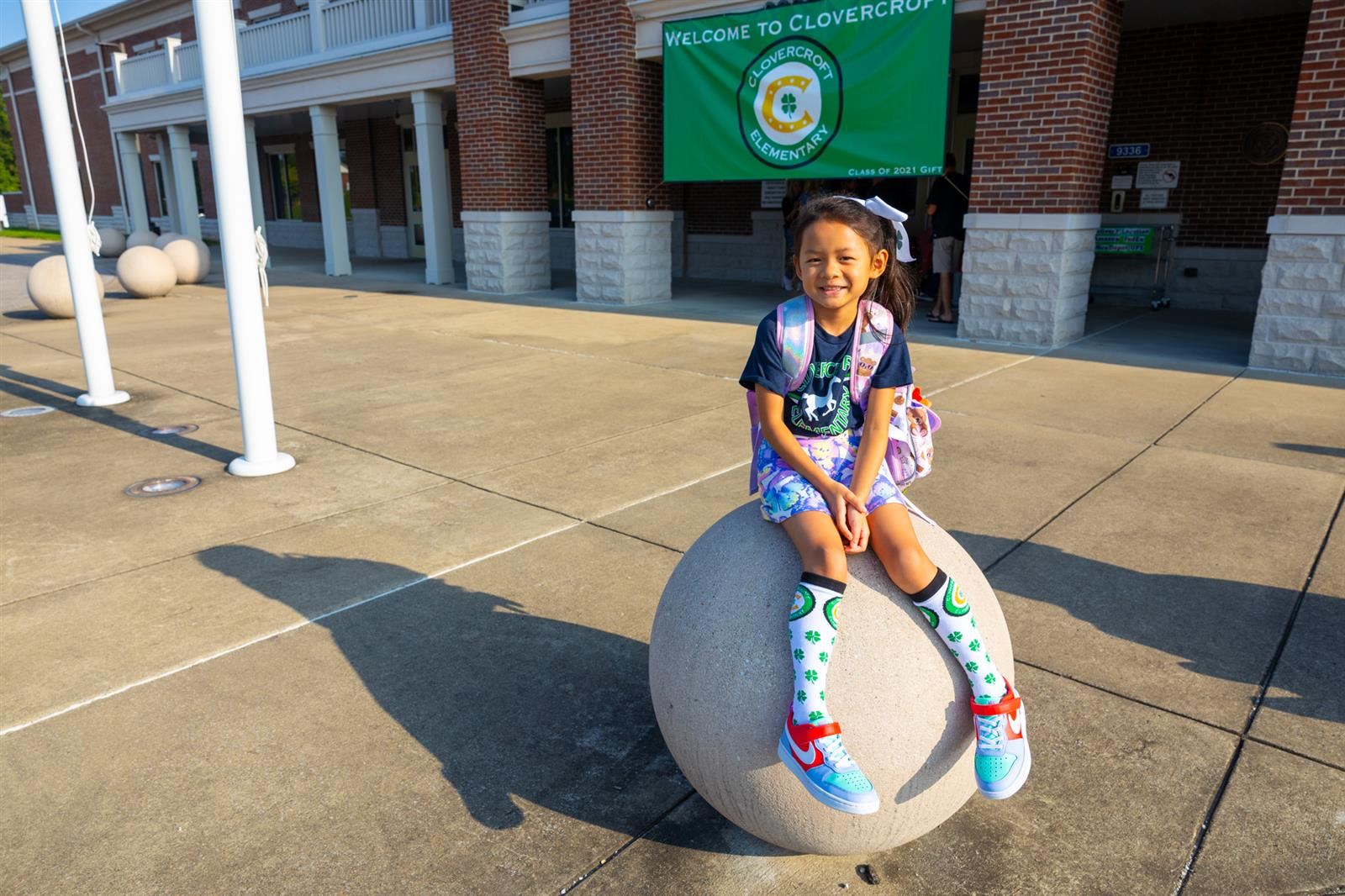 girl sitting on concrete ball